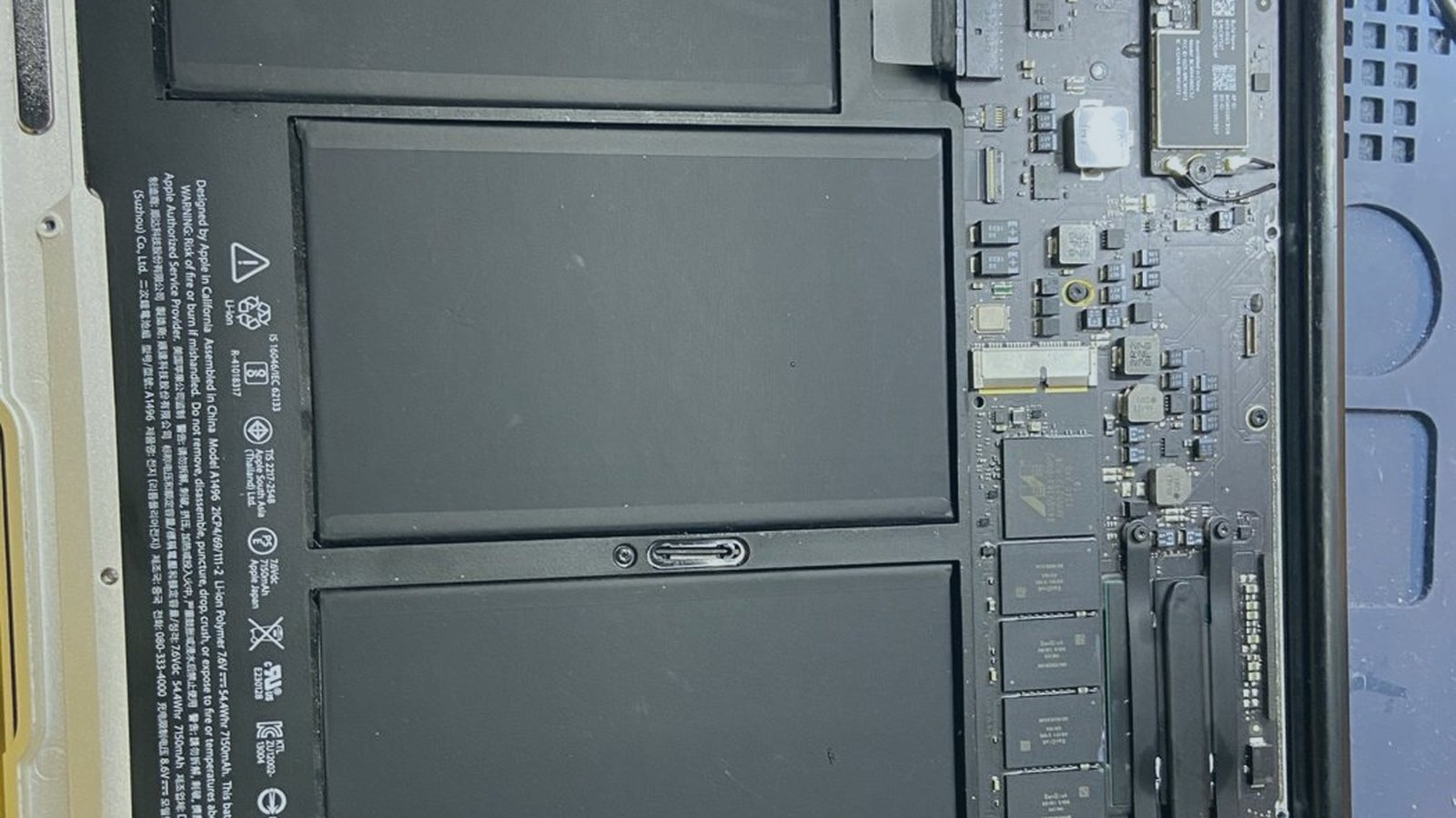 MacBook Air abierta en el taller de EspecialistaMac con las celdas de la batería y la placa a la vista