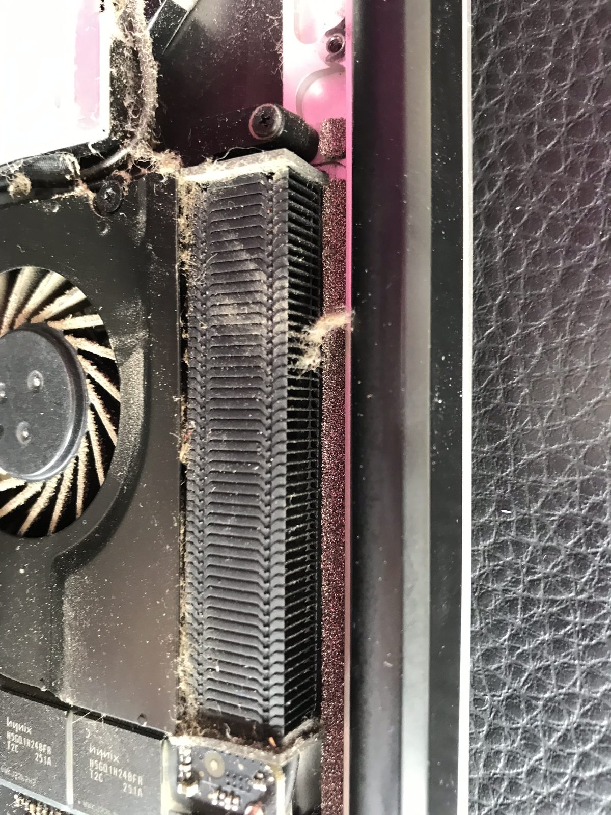 Disipador y ventilador de una MacBook cubiertos por una capa compacta de pelusa
