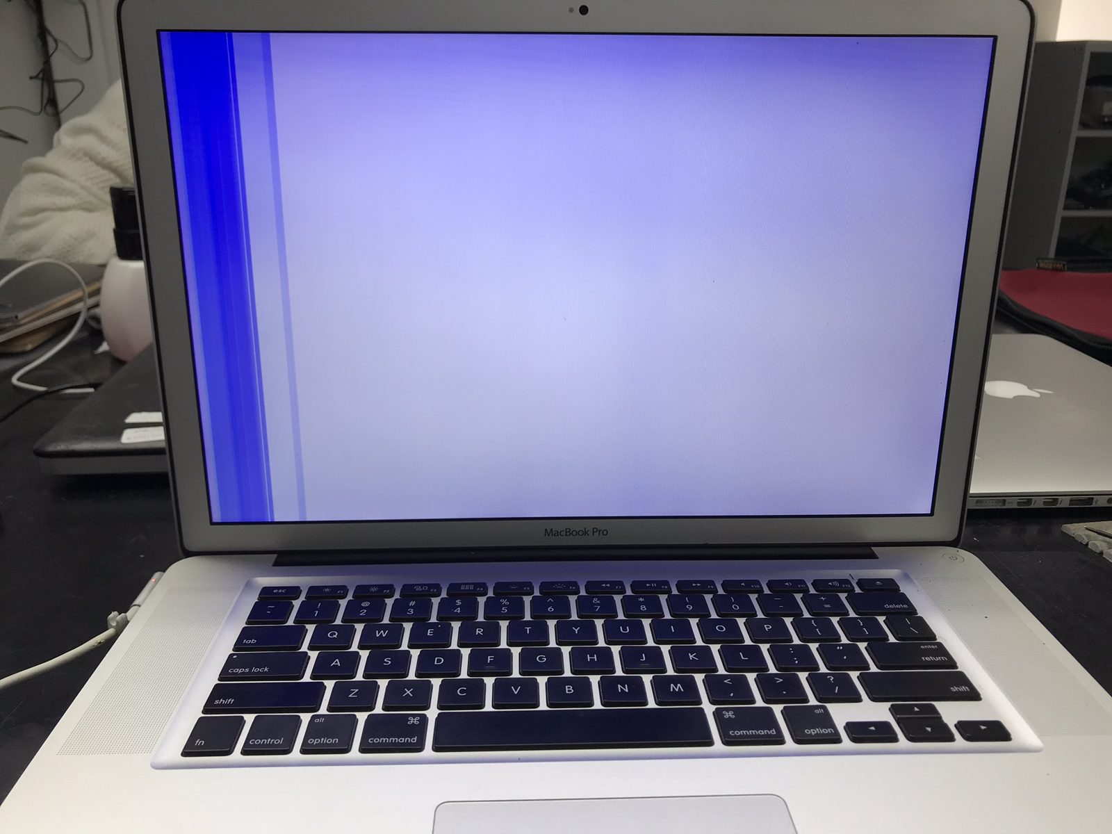 MacBook Pro encendida con una banda vertical azul que cubre casi toda la pantalla