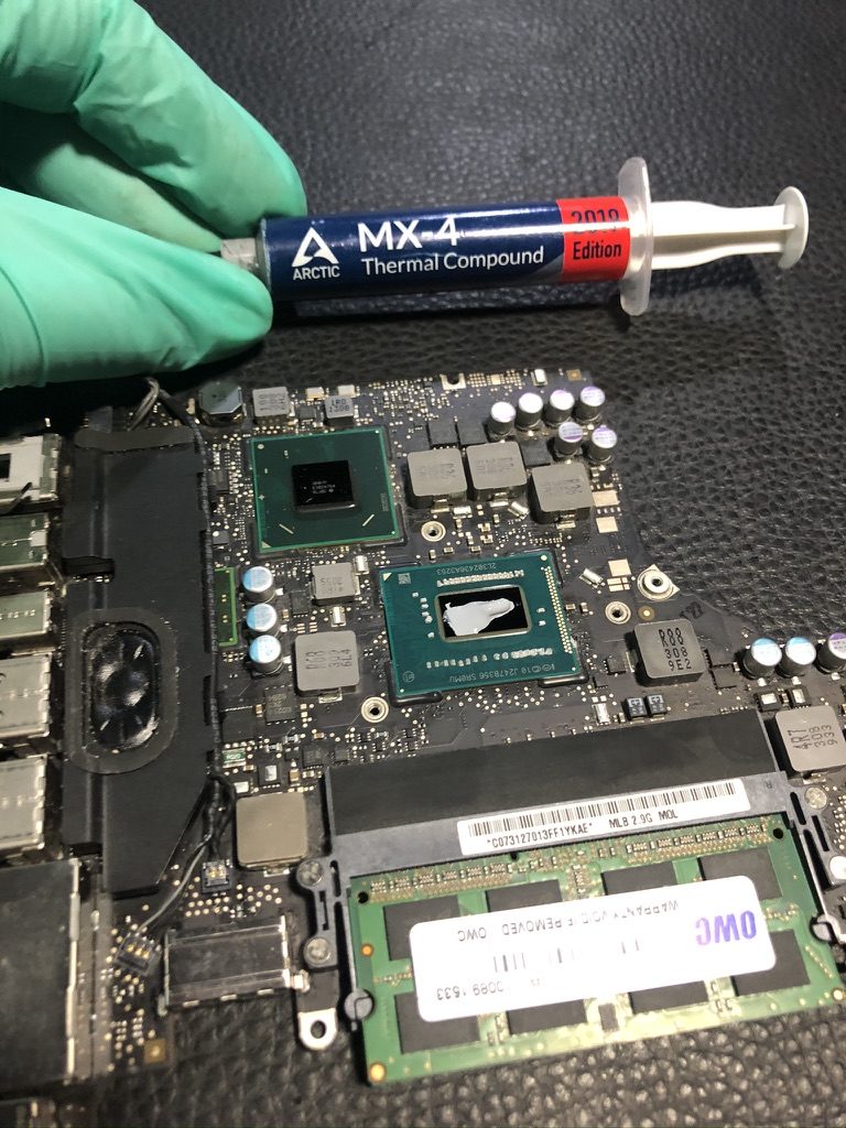 Aplicación de pasta térmica Arctic MX-4 sobre el procesador de una placa de MacBook
