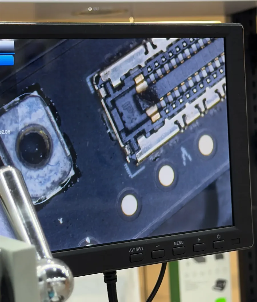 Monitor del microscopio mostrando un conector de placa ampliado, con un pin quemado.