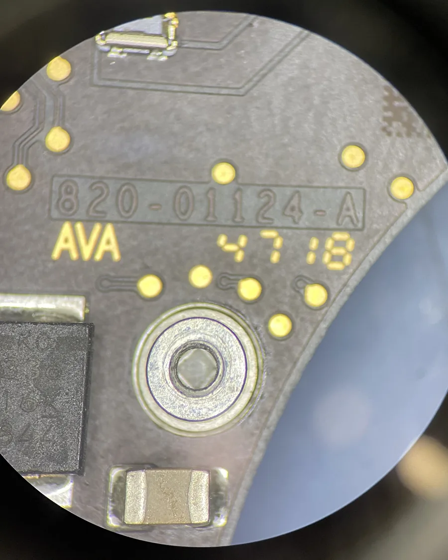Vista por el microscopio de una placa lógica con el número 820-01124-A serigrafiado.