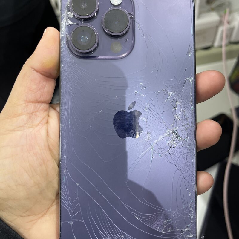 iPhone 14 Pro Max morado con cristal trasero fracturado — ingreso típico al taller EspecialistaMac