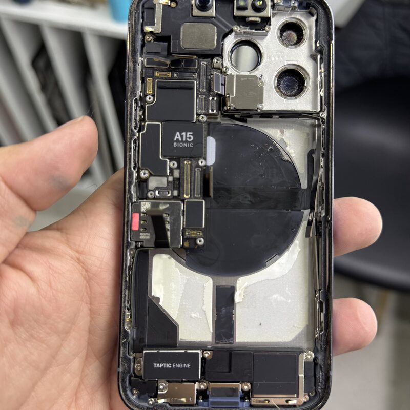 iPhone con chip A15 Bionic completamente desarmado mostrando MagSafe, cámaras y Taptic Engine