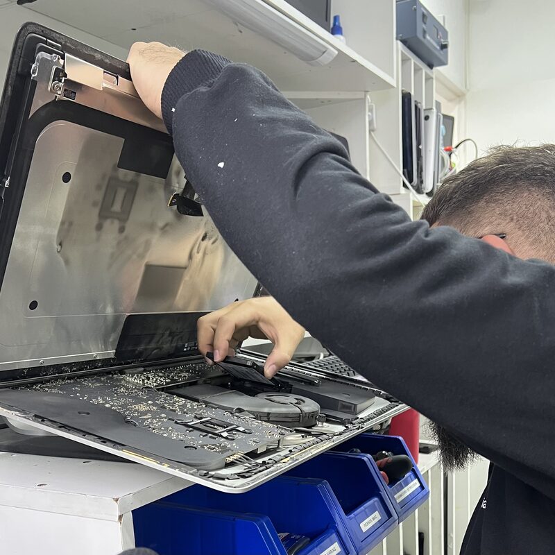Técnico desarmando un iMac en el taller EspecialistaMac de Quito para reparación interna